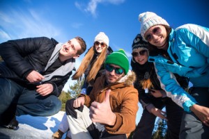 Portrait of Group of teenagers have a good time in winter. Showing Thumbs Up.