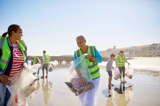 Groupe de personnes qui nettoient une plage