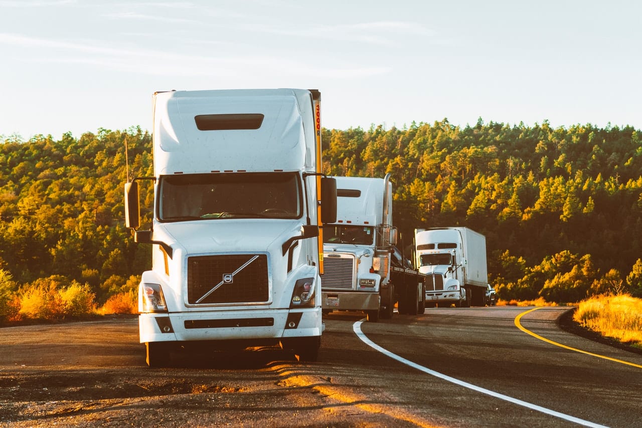 trois camions qui roulent les uns derrière les autres